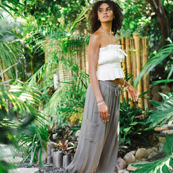 Model standing on walking path amongst dense jungle foliage at Tropic Shots production set