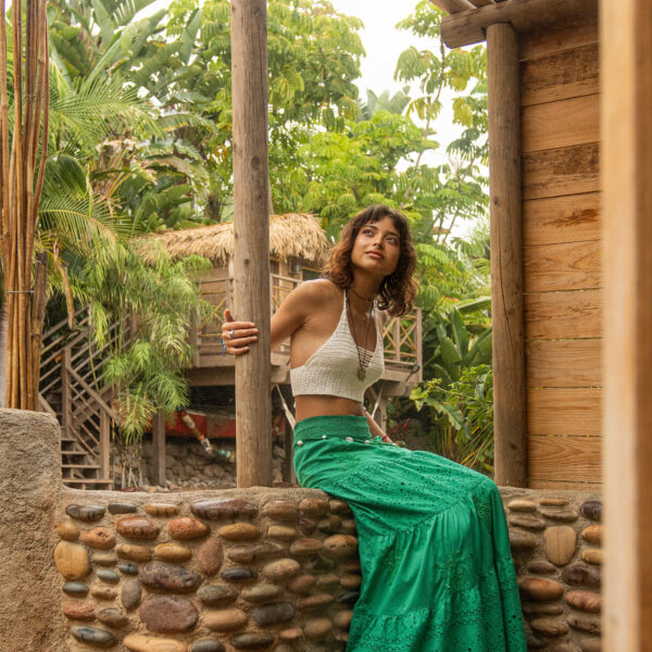 Model sitting on cobblestone outdoor shower during a misty rain, storm with tropical, treehouse, and dense jungle footage at Tropic Shots production set